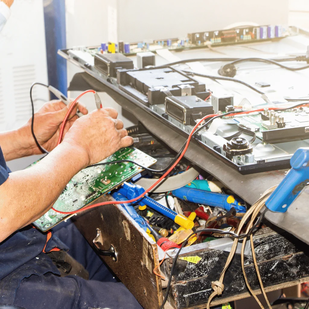 Electronics technicians working in a TV repair workshop